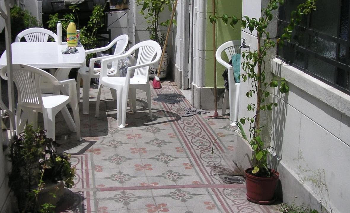 Outdoor dining chairs and table set beside patio planting